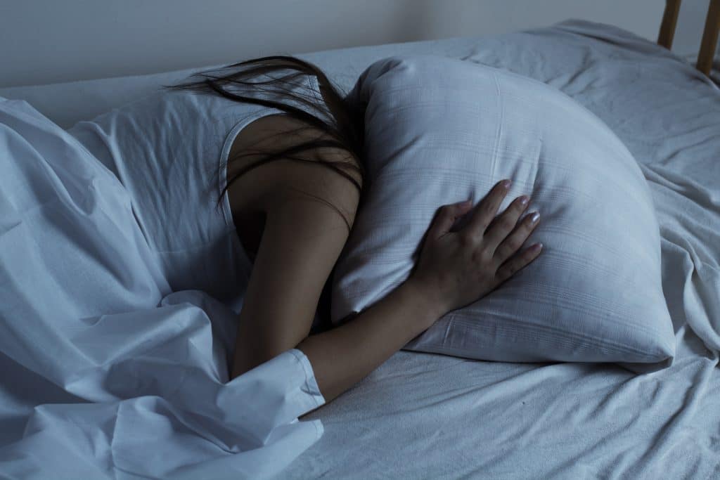 Junge Frau mit Schlafstörungen kann nicht einschlafen