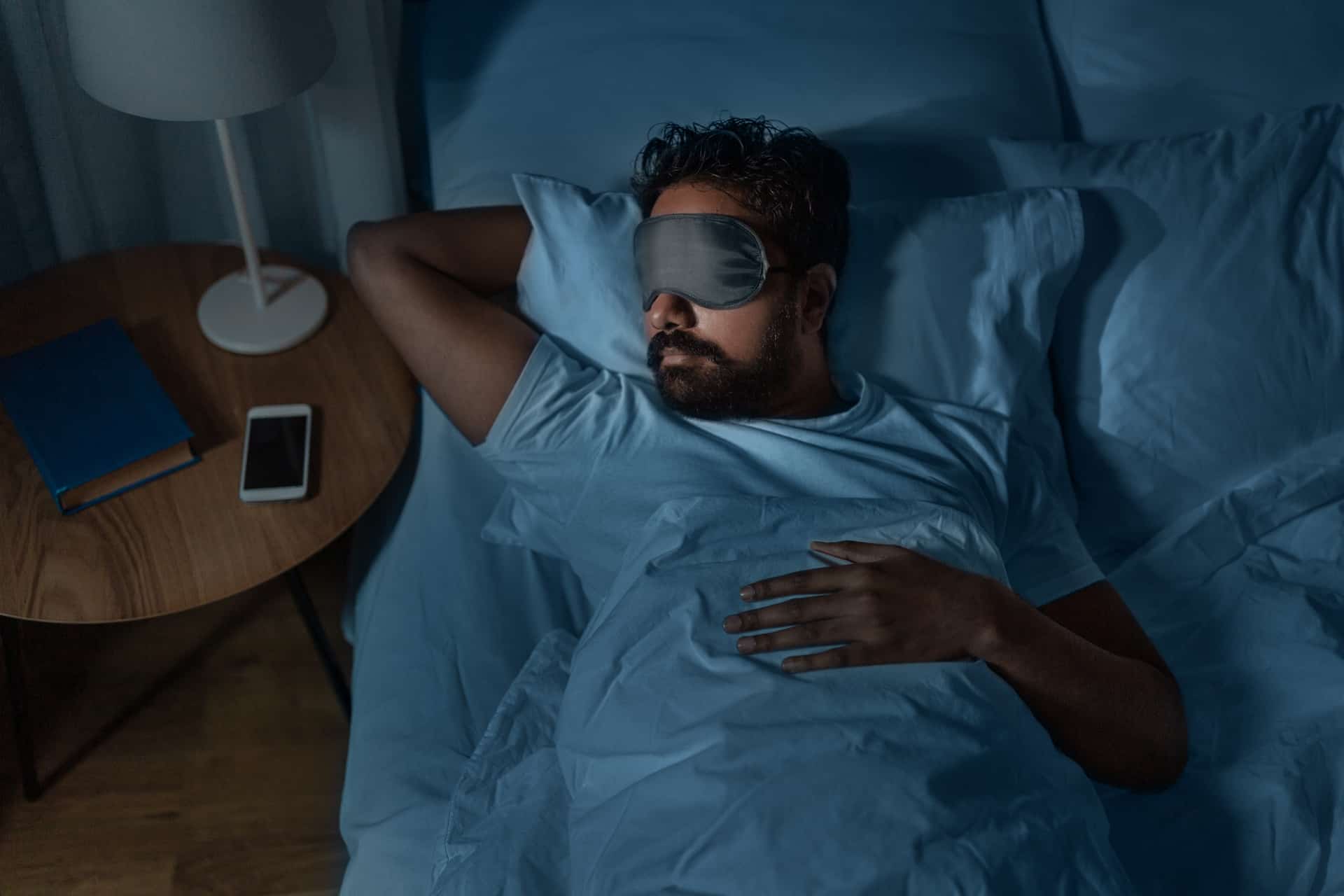 Junger Mann versucht mit Schlafbrille zu schlafen