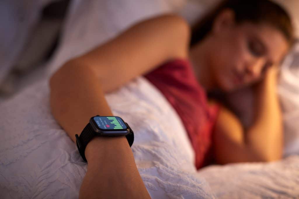 Junge Frau nutzt Schlaf-Apps zur Kontrolle Ihrer Schlafqualität