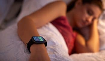 Junge Frau nutzt Schlaf-Apps zur Kontrolle Ihrer Schlafqualität
